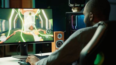 Profesyonel oyuncu yoğun online çok oyunculu video oyununda canlı oturma odasından neon ışıklarla canlı yayında yarışıyor. Bilgisayarı kullanan, oyun sırasında kendini kaptırmış bir adam, kamera A