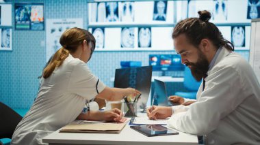 En iyi tedaviyi bulmak için anatomi x ışını taramalarını inceleyen tıp uzmanları, araştırma toplantısı. Radyoloji ve tanı konularında takım çalışması ve uzmanlığı sigortanın iyileşmesini sağlar. Kamera B.