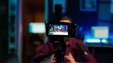 İçerik yaratıcısı rgb lights stüdyosunda online şov sunuyor, profesyonel ekipman kullanarak video bloğu çekiyor. Kamera ve kamera A ile çekilen yayın sırasında bilgi sunan Vlog kaydedici