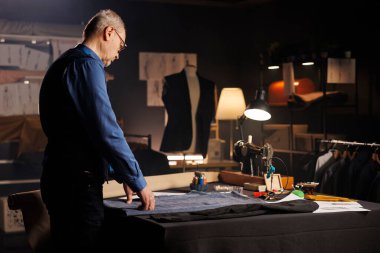 Profesyonel terzilik stüdyosunda tek başına kılık değiştiren yaşlı uzman moda koleksiyonu tasarlıyor. Atölye atölyesinde kıdemli bir zanaatkar atölye çalışması için kaliteli kıyafetler üretiyor.