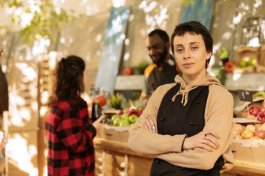 Yerel bir markette sağlıklı yiyecek satan, mevsimlik taze meyve ve sebze sergileyen bir kadın çiftçinin portresi. Genç bayan satıcı çevre dostu organik ürünler satmaya hazırlanıyor..