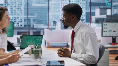 Başvuru sahibi, iş görüşmesine başlamaları için CV 'sini insan kaynakları personeline sunarak, başvuru formundaki nitelik ve iş deneyimlerini gözden geçiriyor. Mevcut iş rolleri tartışılıyor. Kamera A.