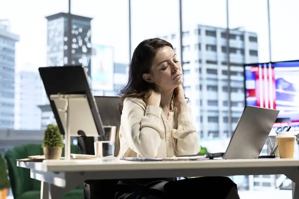 stock image Woman boss suffers from office syndrome due to incorrect pose at the desk, having neck and back ache while she works on her business. Female leader with cramps and sedentary life.