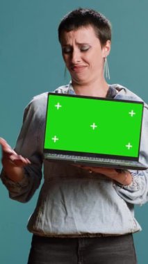 Stüdyoda elinde fotokopi odası olan bir dizüstü bilgisayar tutan dikey video tarzı bir kadın, sokak tarzı ve koyu renk makyajlı bir reklam yaratıyor. Kendine güvenen, havalı bir kadın model. Kamera B.