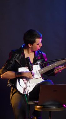 Dikey video rock sanatçısı prova sırasında performans hazırlığı yapıyor, canlı bir gösteri için vokallerini prova ediyor. Isınma turunda şarkı söyleyen müzisyenler ses gelişimine odaklanıyorlar. Kamera B.