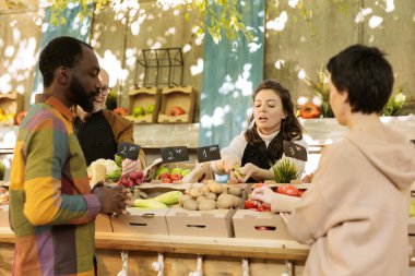 Çiftçi pazarı sahibi yerel stantta bedava elma numunesi veriyor, müşterilere taze biyolojik ürünler sunuyor. Genç kadın çiftçi meyve ve sebze kesiyor organik ürünler, sağlıklı yiyecekler..