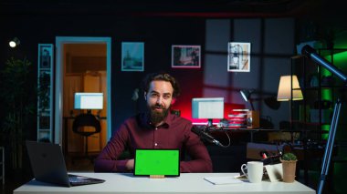 Stüdyoda gülümseyen adam teknoloji meraklıları için krom anahtar değerlendirmesi yapıyor. Neşeli çevrimiçi yıldız teknoloji internet şovuna ev sahipliği yapıyor, yeşil ekran dijital taşınabilir cihaz, kamera B