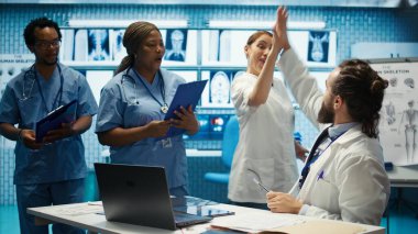 Başarılı bir araştırma seansından sonra bir hastalıkla savaşmak için en iyi tedaviyi bulan mutlu sağlık ekibi beşliği paylaşıyor. İyi haberleri kutlayan yetkili personel. Kamera B.