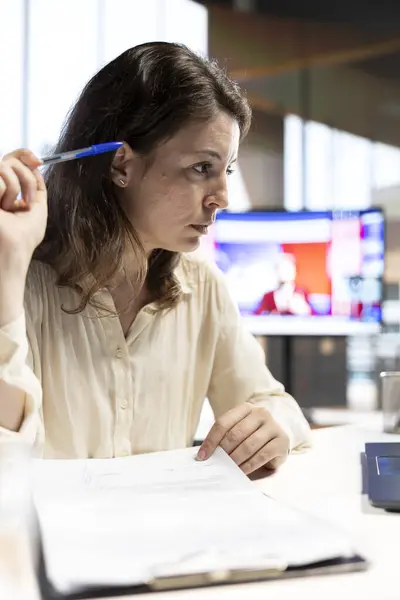 stock image Female leader signing legal management documents and contracts, giving her authorization for license agreements and leave requests from employees. CEO deals with paperwork in office.