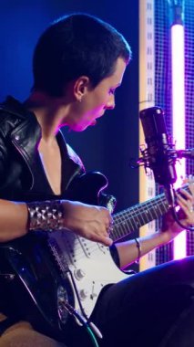 Dikey video rock sanatçısı prova sırasında performans hazırlığı yapıyor, canlı bir gösteri için vokallerini prova ediyor. Isınma turunda şarkı söyleyen müzisyenler ses gelişimine odaklanıyorlar. Kamera A.
