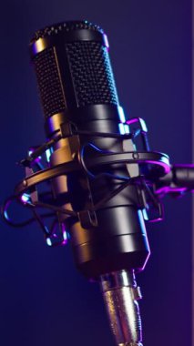 Dikey video kayıt stüdyosu, retro sahnede lüks bir mikrofonla elektronik ve modern ekipmanlarda müzikal melodiler ve akustik melodiler üretiyor. Canlı yaratıcı konser. Kapat..