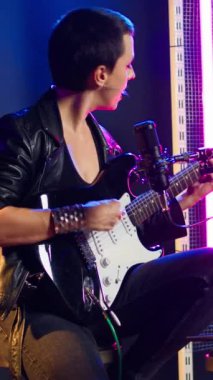 Dikey video Sevinçli punk rock sanatçısı canlı performansı için prova yapıyor, vokal eğitimine odaklanıyor ve ısınıyor. Alternatif müzikle pratik yapmaktan hoşlanan sinirli ikonik kadın. Kamera A.