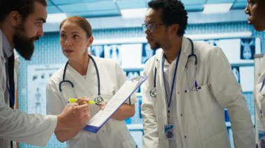 Tıbbi uzmanlardan oluşan bir ekip, bir hastalık için tedavi sağlamadan önce sağlık kayıtları üzerinde x ışını test sonuçlarını vurguluyor. Doktorlar hızla iyileşmesini sağlıyorlar. Kamera B.