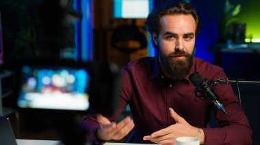 Medya yıldızı, yapımcı ekipmanlarıyla birlikte geceleri RGB ışıklarıyla aydınlatılan video kaydını yaparken kendinden bahsediyor. Profesyonel mikrofonla konuşan bir şovmen, kamera A.