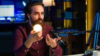 Stüdyoda teknoloji uzmanı tarafından izleyicilere nasıl tamir edileceğini öğretmek için kullanılan akıllı ampul, el kameralı çekim. Medya yıldızı kamera A tarafından tutulan IoT ev otomasyon ürününe odaklan