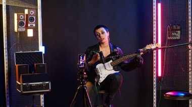 Stüdyoda ses eğitimi için çevrimiçi bir ders kaydeden şarkı söyleme koçu, canlı yayın dersi üzerine ses alıştırmaları. Heavy metal çalan bir müzik hocası temel şeyleri öğretiyor. Kamera B.