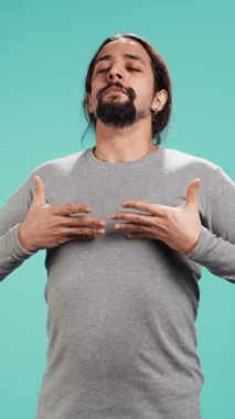 Rahatlamak, pozitif enerji kazanmak ve stresi ortadan kaldırmak için insanın nefes alıp verişinin dikey videosu. Stüdyonun arka planında izole edilmiş solunum egzersizleri yapan kişi, kamera B