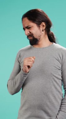 Dikey Videocu, pis kokuya tepki olarak burnunu kırıştırır, stüdyo arka planında izole olur. Tiksindirici yüz ifadesi olan, tiksindirici koku alan, hoşnutsuzluk ve rahatsızlık duyan biri.