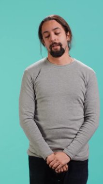 Sıkılmış bir adamın dikey video portresi hiçbir şey yapmaya hevesli değil, esniyor, zaman kaybediyor, stüdyo arka planında soyutlanıyor. Uykulu, sıkıcı bir yüz ifadesi olan, monoton bir hayat yaşayan tembel insan.