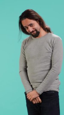 Utangaç bir adamın saçlarında parmakları olan, aşık olan, stüdyo çekimlerinde izole edilmiş dikey video portresi. Çekingen insan, aşık olduğunda gergin olur, duygularını ifade etme ihtiyacı hisseder.