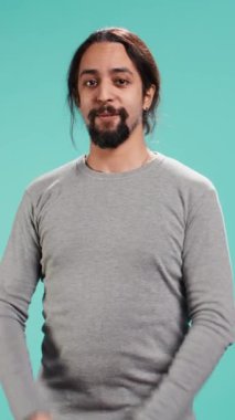 Dikey video parçalayıcı neşeli adam mutlu bir şekilde el çırpıyor, iyi haberler almak için sabırsızlanıyor. Heyecanlı insanlar tezahürat yapıyor, alkışlıyor, umutlu ve hevesli hissediyor, stüdyo arka planında izole edilmiş, kamera B