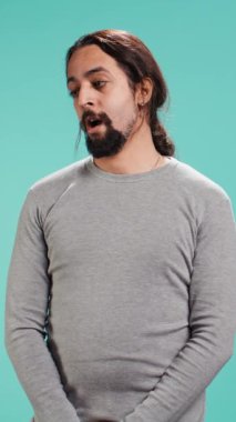 Sıkılmış bir adamın dikey video portresi hiçbir şey yapmaya hevesli değil, esniyor, zaman kaybediyor, stüdyo arka planında soyutlanıyor. Uykulu, sıkıcı bir yüz ifadesi olan, monoton bir hayat yaşayan tembel insan.