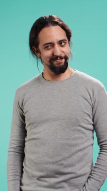 Dikey video Bersagliera özgüvenli adam kameraya göz kırpıyor, flört ediyor. Dudaklarını ısıran, aşk çocuğu gibi davranan, romantik jestler yapan, stüdyo arka planında izole edilmiş, kamera B