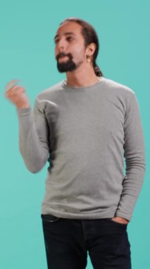 Dikey videolu neşeli adam umursamaz ve kaygısız davranışlar sergiliyor. Keyifli ve rahat bir insanın portresi, özgüvenini, stüdyo geçmişini, kamera A 'yı gösteriyor.