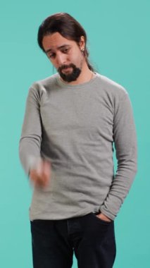 Kötü haberlerle sarsılmış ve üzgün hisseden sorunlu bir adamın dikey video portresi stüdyo arka planında izole edilmiş. Ağlamanın eşiğindeki sıkıntılı kişi, sorunlu olaylar yüzünden nutku tutulmuş, kamera A