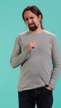 Dikey Videocu, pis kokuya tepki olarak burnunu kırıştırır, stüdyo arka planında izole olur. Tiksindirici yüz ifadesi olan, tiksindirici koku alan, hoşnutsuzluk ve rahatsızlık duyan biri.