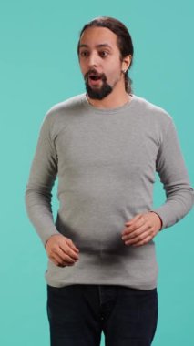 Etrafa hayranlıkla bakan neşeli, şen gözlü bir adamın dikey video portresi. Güzel bir çevre ve stüdyo arka planından büyülenmiş. Heyecanlı meraklı insan etrafındaki manzaraya hayran, kamera A