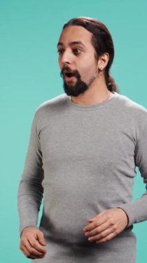 Etrafa hayranlıkla bakan neşeli, şen gözlü bir adamın dikey video portresi. Güzel bir çevre ve stüdyo arka planından büyülenmiş. Heyecanlı meraklı insan etrafındaki manzaraya hayran, kamera B