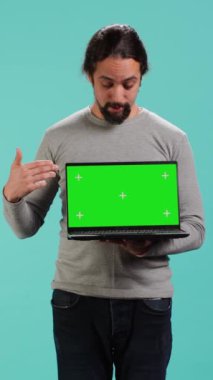 İzole edilmiş ekran bilgisayarı tutan işçilerin dikey video portresi şirket için önemli işler yapıyor, stüdyo arka planı. İş yerinde krom anahtar cihazı olan bir çalışan iş görevlerini çözüyor, kamera A