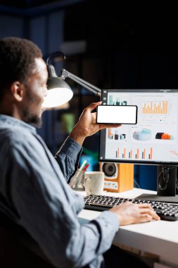 Beyaz ekran şablonuyla çalışan Afrikalı Amerikalı bir adam, bilgisayardaki iş operasyonlarını çözmek için çevrimiçi analiz kullanıyor. Serbest Yazıcı sunum oluşturuyor, boş ekran.