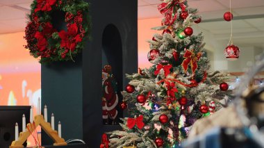 Güzel dekore edilmiş Noel ağacı ve alışveriş merkezindeki şenlikli giyim mağazasında süslemeler. Xmas, kış tatili boyunca müşterileri bekleyen moda mağazalarını süslüyor