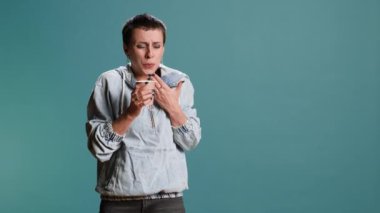 Kadın model bir fincan kahve içiyor ve stüdyoda dilini yakıyor, sıcak kafein içeceğiyle kendine zarar veriyor. Günlük giysiler içinde şık bir kadın serinletici bir şeyler içiyor. Kamera B.