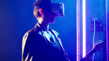 Gece kulübünde canlı yayın sırasında sanal gerçeklik kulaklığı kullanan, elektro gitar çalan ve VR gözlük takan bir bayan müzisyen. Deri giyen kadın rock yıldızı metal döver. Kamera A.