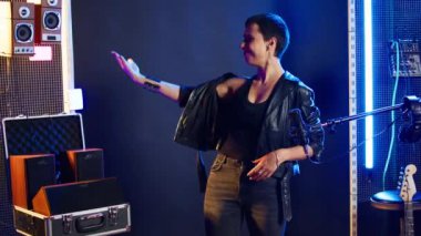 Müzikal yetenekli vokalist dilsiz sembolünün sessiz olduğunu gösteriyor,... güçlenmeyi vurguluyor ve nefret yok. Rock yıldızı kadın, kültürel bir açıklama için sus işareti yapıyor, isyankar tavır. Kamera A.