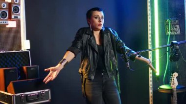Heavy metal sanatçısı kararsız davranıyor ve şüphe içinde omuz silkiyor, bir cevap hakkında bilgisiz ve kararsız. Kafası karışmış kadın sanatçının bir şeyden haberi yok. Kamera A.