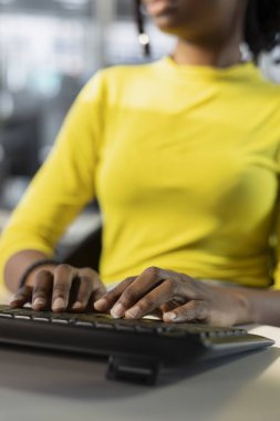 Meticulous accountant imputing revenue figures on computer in office. Adept employee at desk focused on typing company statistical numbers, working hard to finish job before deadline clipart