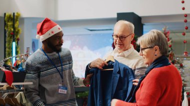 Xmas mağazasındaki perakende asistanı Noel çılgınlığı sırasında üst düzey çiftlere yardım ediyor. Kış tatili boyunca yaşlı müşterilere danışmanlık yapan işçiler