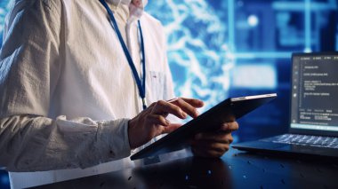 Veri merkezindeki bilgisayar bilimcisi, bilgisayardaki programlama senaryolarını çalıştırırken tablet üzerindeki görevleri çözüyor. Yapay zeka uygulamalarının geliştirilmesi için kodları değiştiren sertifikalı mühendis
