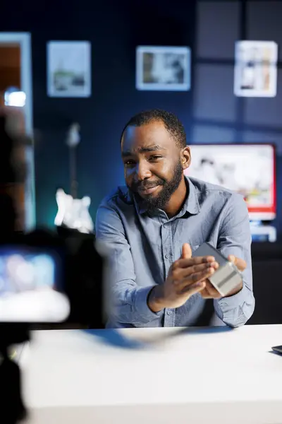 stock image Tech guru assessing portable speaker performance, expressing dissatisfaction with subpar components used. Man shoots Bluetooth audio device review for online channel, displeased with low quality