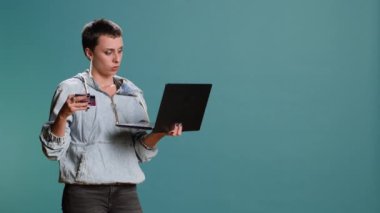 Genç bir kadın mağaza sitesine sipariş veriyor ve kıyafetlere para harcıyor, şık bir kız uzaktan kredi kartı ödeme yöntemini seçiyor. Satın alınması gereken ticaret ve tüketim. Kamera B.