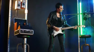 Kendine güvenen bayan rockçı sahnede canlı performans sergiliyor. Cesur stili ve güçlü rock yıldızı enerjisini gösteriyor. Yüksek sesli heavy metal canlı performansı, punk rock. Kamera A.