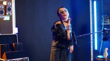 Cesur grunge rock yıldızı, hayranlarına havadan öpücükler yolluyor. Kulüpteki seyircileriyle flört ediyor ve özgüvenini gösteriyor. Kadın sanatçı konser sırasında şakacı oluyor. Kamera A.