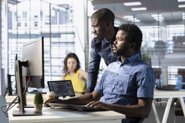 Özenli ofis memurları veri tabanlarını analiz eder, pazarlama grafiklerini karşılaştırır ve bilgisayardaki muhasebe rakamlarını kontrol eder. Takım çalışanı iş yerinde takım projesi için görevleri çözen meslektaşlar