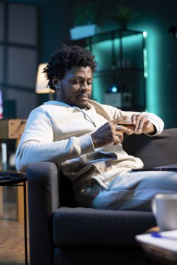 İşyerinde maaş zammı aldıktan sonra internetten alışveriş yapan, bilgisayardan kredi kartı bilgilerini yazan bir adam. BIPOC çalışanı gecenin geç saatlerinde neon ışıklı odada web sitesine ödeme yöntemi ekliyor