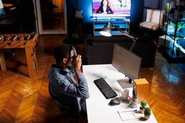 Ağ operatörü betiği güncelliyor ve PC üzerinde terminal arayüzde HTML kodu ile IT dilini birleştiriyor. Serbest çalışan donanım programcısı veritabanlarını ve teknik desteği kontrol ediyor.