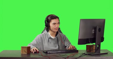 Bilgisayarda Asyalı bir oyuncu, dünyanın dört bir yanındaki insanlarla internet video oyunları oynuyor. Genç insan rol yapma yarışmasında eğleniyor, arkadaşlarıyla yeşil ekran üzerinden iletişim kuruyor.